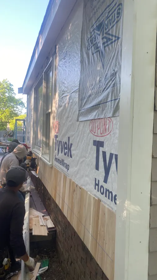 Cedar shingle siding installation in golden evening light