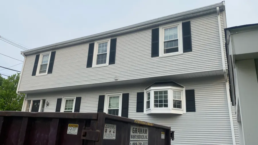 Finished gray siding installation with black shutters