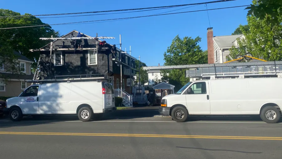 Gregos Home Improvement work vehicles on a roofing job site